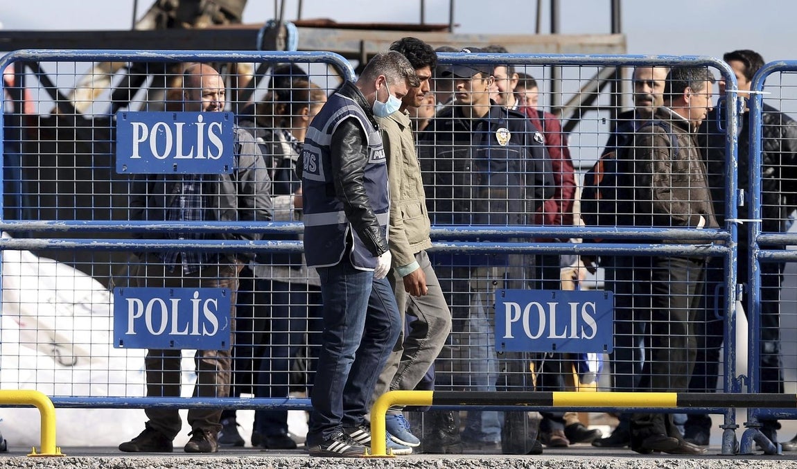 La Policía escolta a un grupo de refugiados provenientes de la isla griega de Lesbos a su llegada a Turquía. 
