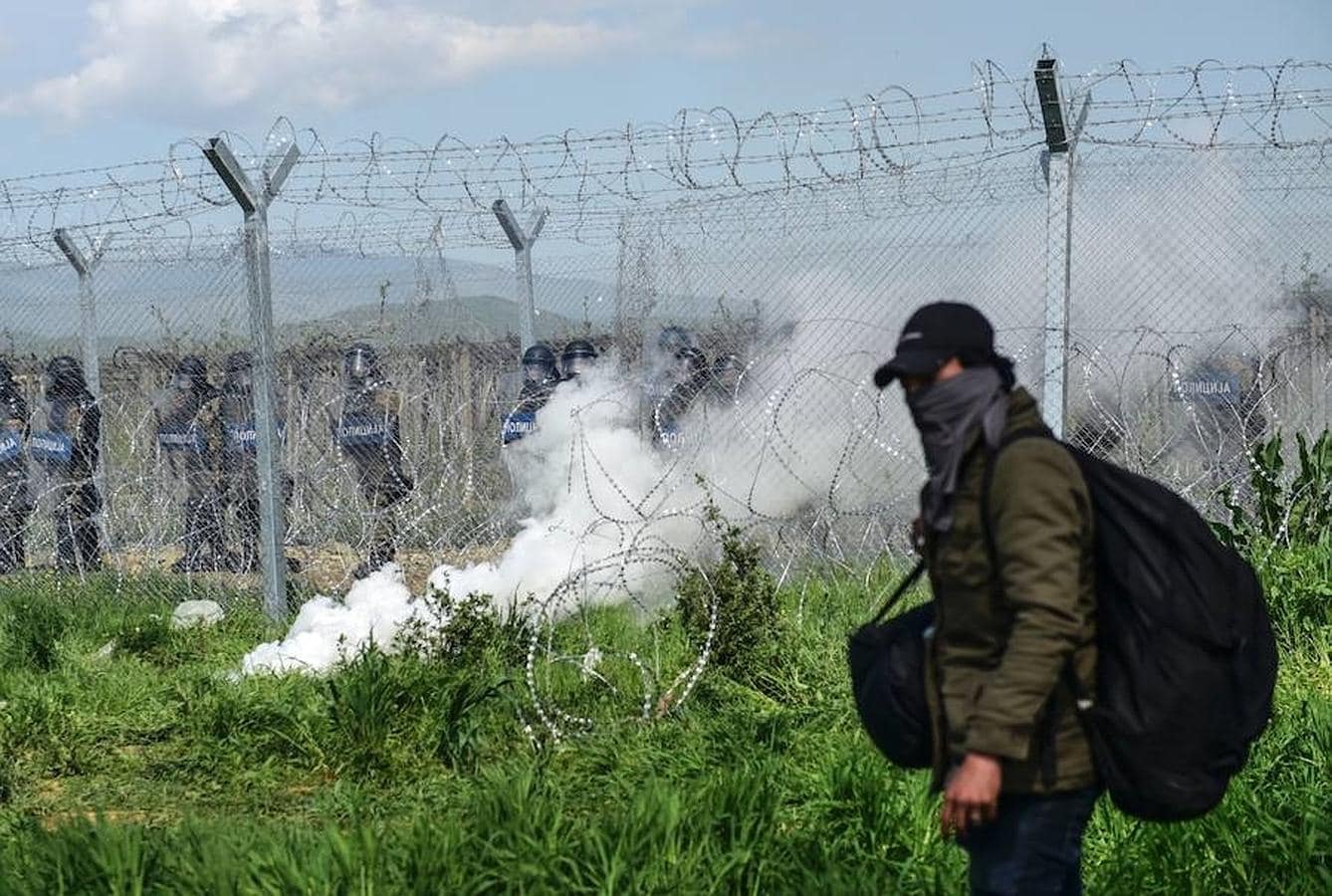 Los refugiados se ponen mascarillas para evitar el gas lacrimógeno