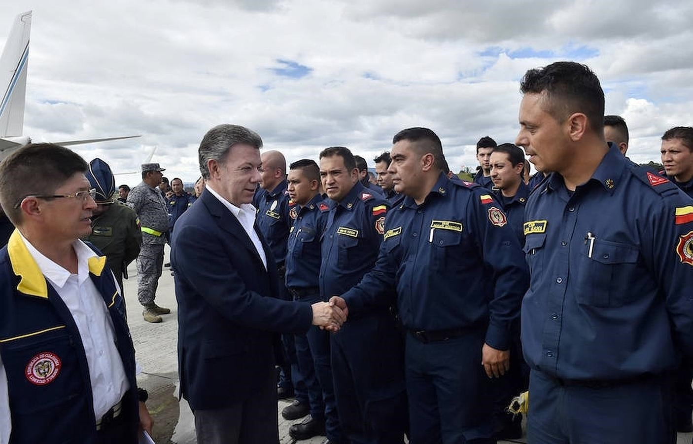 El presidente de Colombia, Juan Manuel Santos (2i), durante un saludo a uno de los 65 socorristas que partirán hacía Ecuador para ayudar en las labores de rescate. 