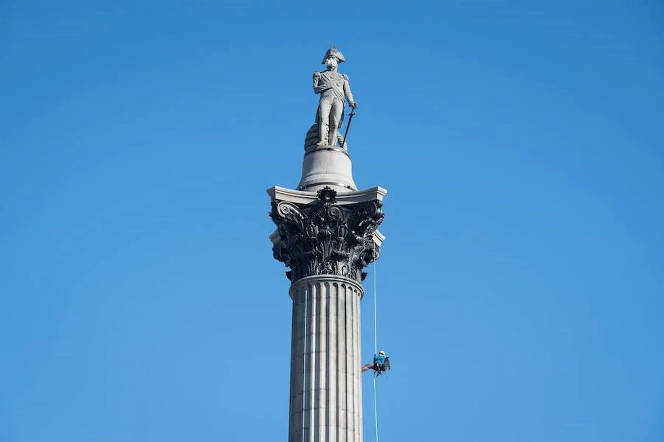 Miembros de Greenpeace ponen una mascarilla en lo alto de la columna del almirante Nelson, en Trafalgar Square