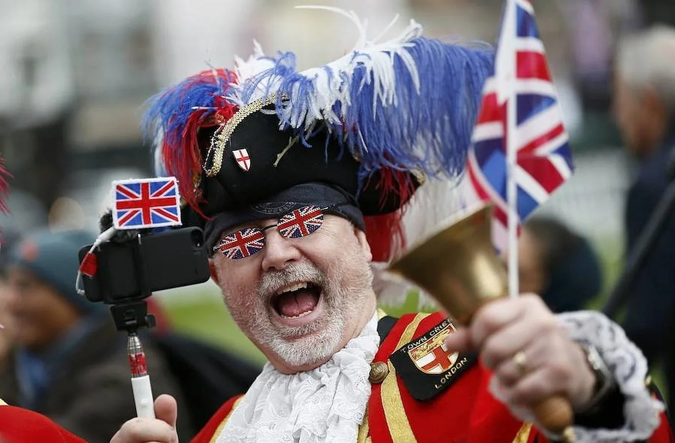 Un fan de la Reina disfrazado y con distintivos de la Union Flag en las gafas y el teléfono