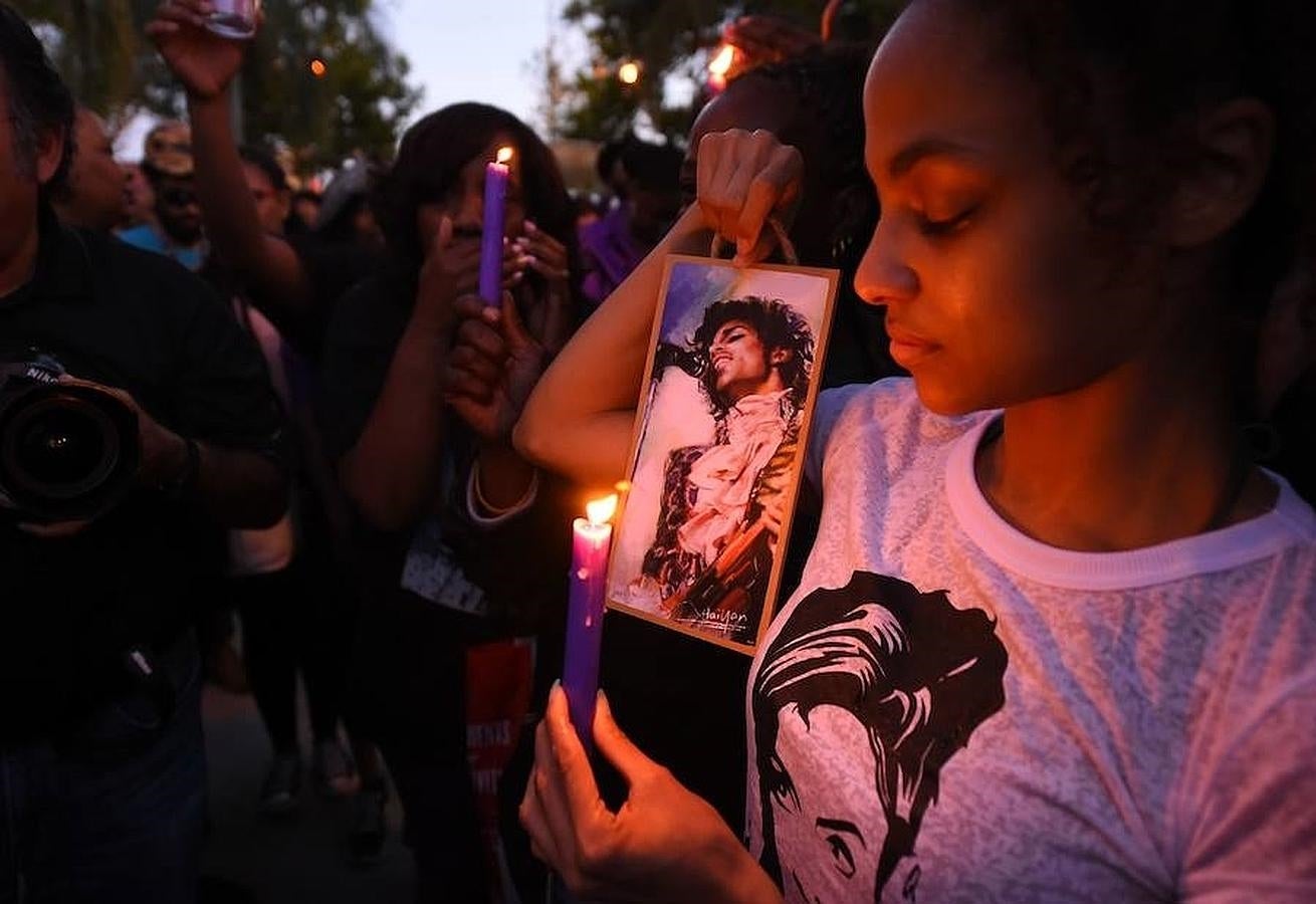 Candiles y velas con la foto de Prince en una actuación