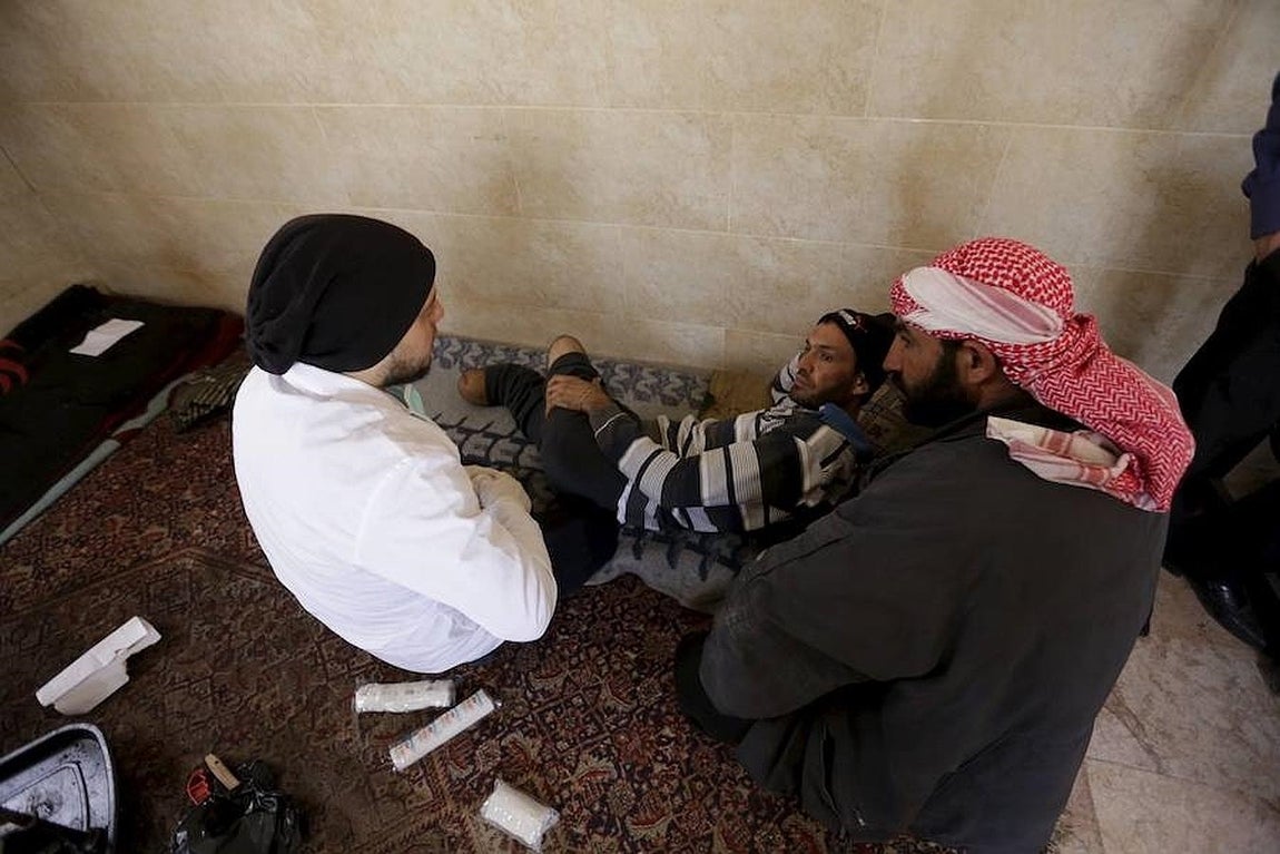 Khamis habla con un hombre con ambas piernas amputadas. 