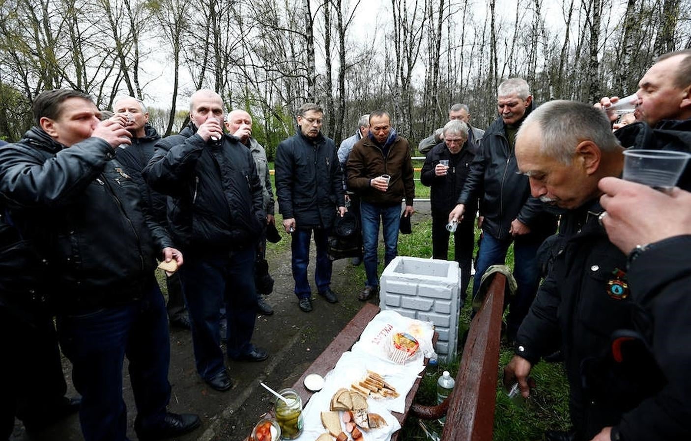 Hombres que participaron como «liquidadores» recuerdan a sus compañeros muertos bebiendo vodka, tras la ceremonia oficial. 