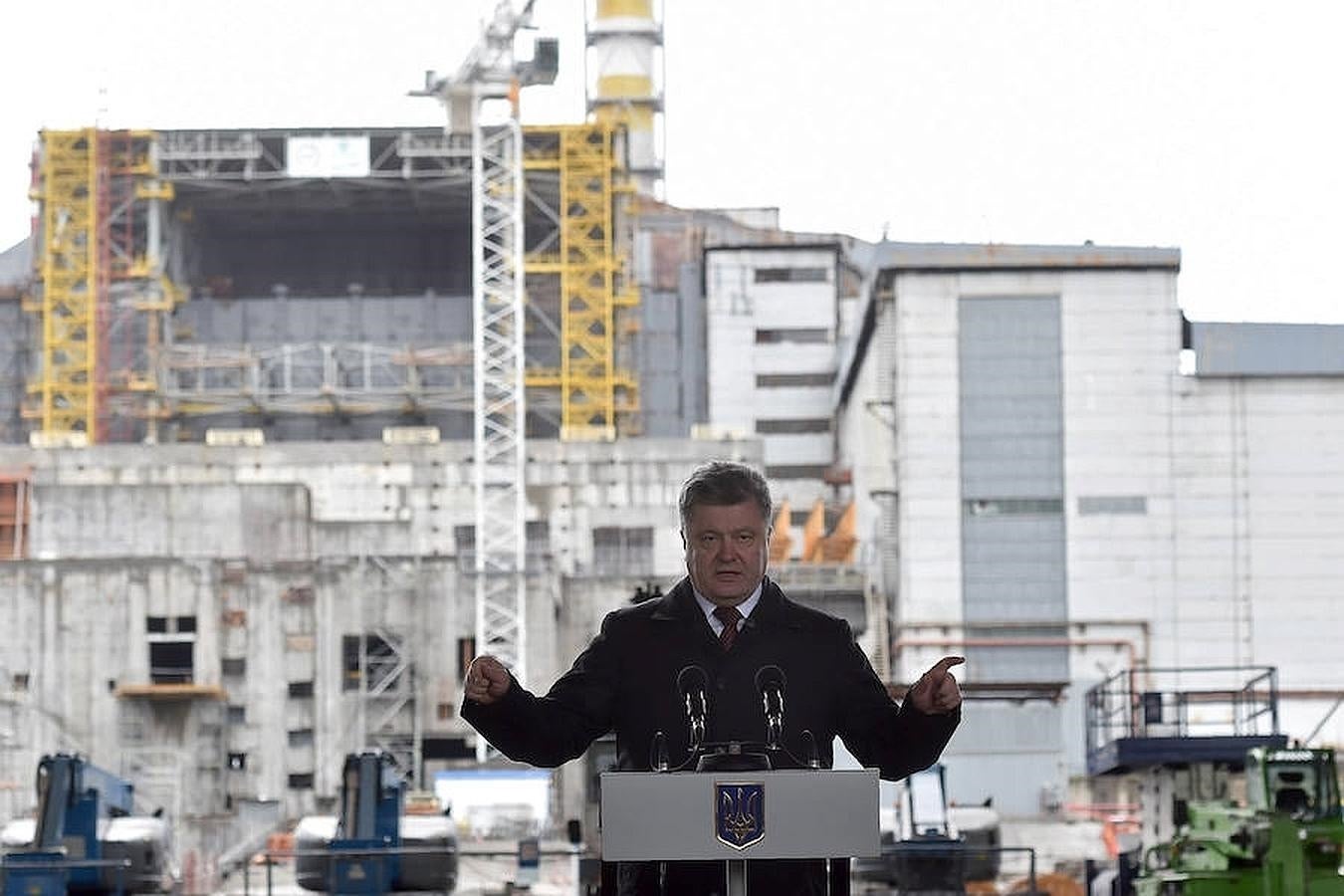 El presidente ucraniano, Petro Poroshenko, pronuncia un discurso durante la ceremonia de conmemoración del 30 aniversario de la catástrofe de Chernóbil. Al fondo se puede ver el sarcófago que cubre el cuarto reactor de la central nuclear, que sufrió la explosión en 1986. 