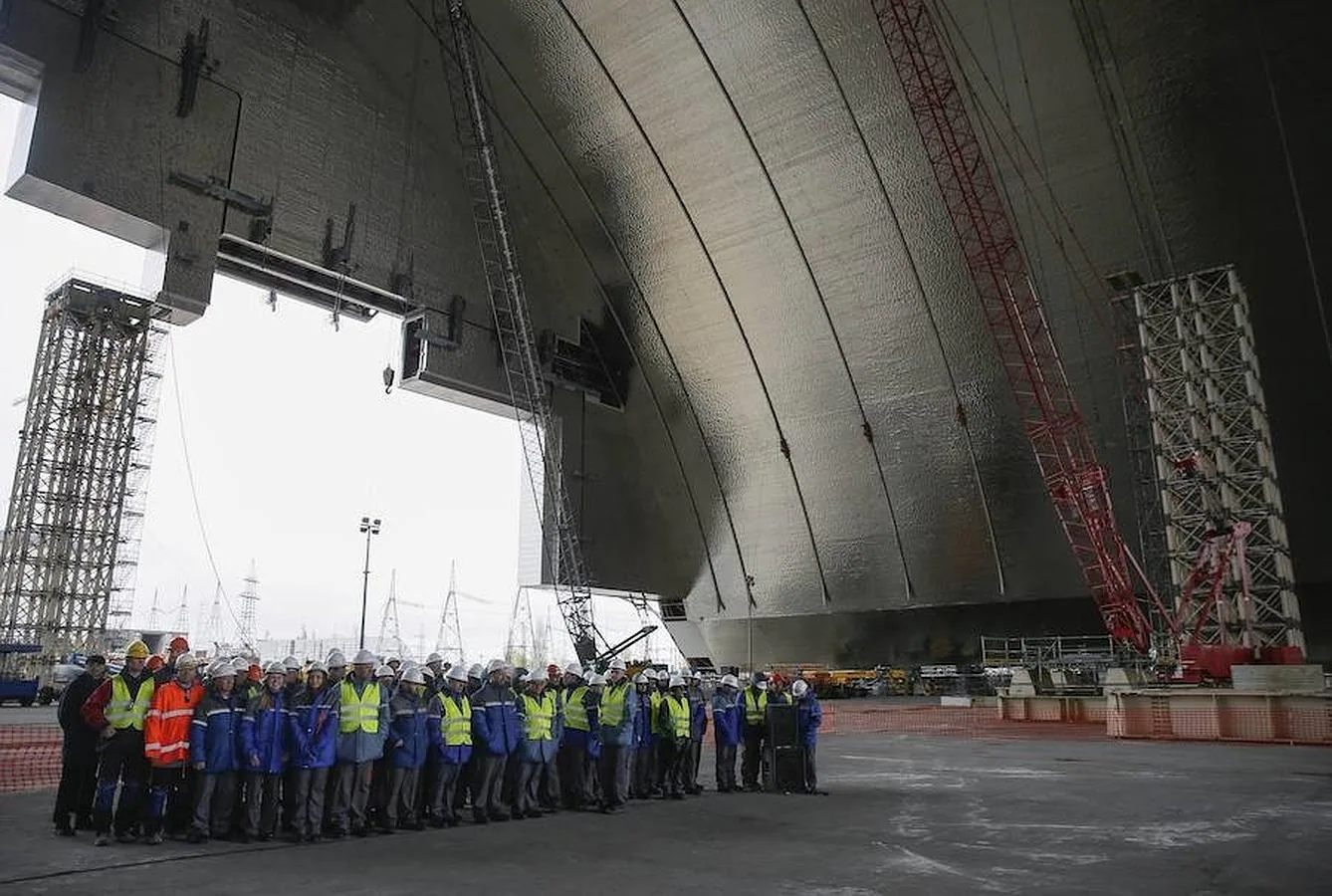 Los trabajadores de la planta nuclear de Chernóbil posan durante una ceremonia con motivo de la construcción de las nuevas instalaciones sobre los restos del reactor número 4, en la planta nuclear de Chernóbil 