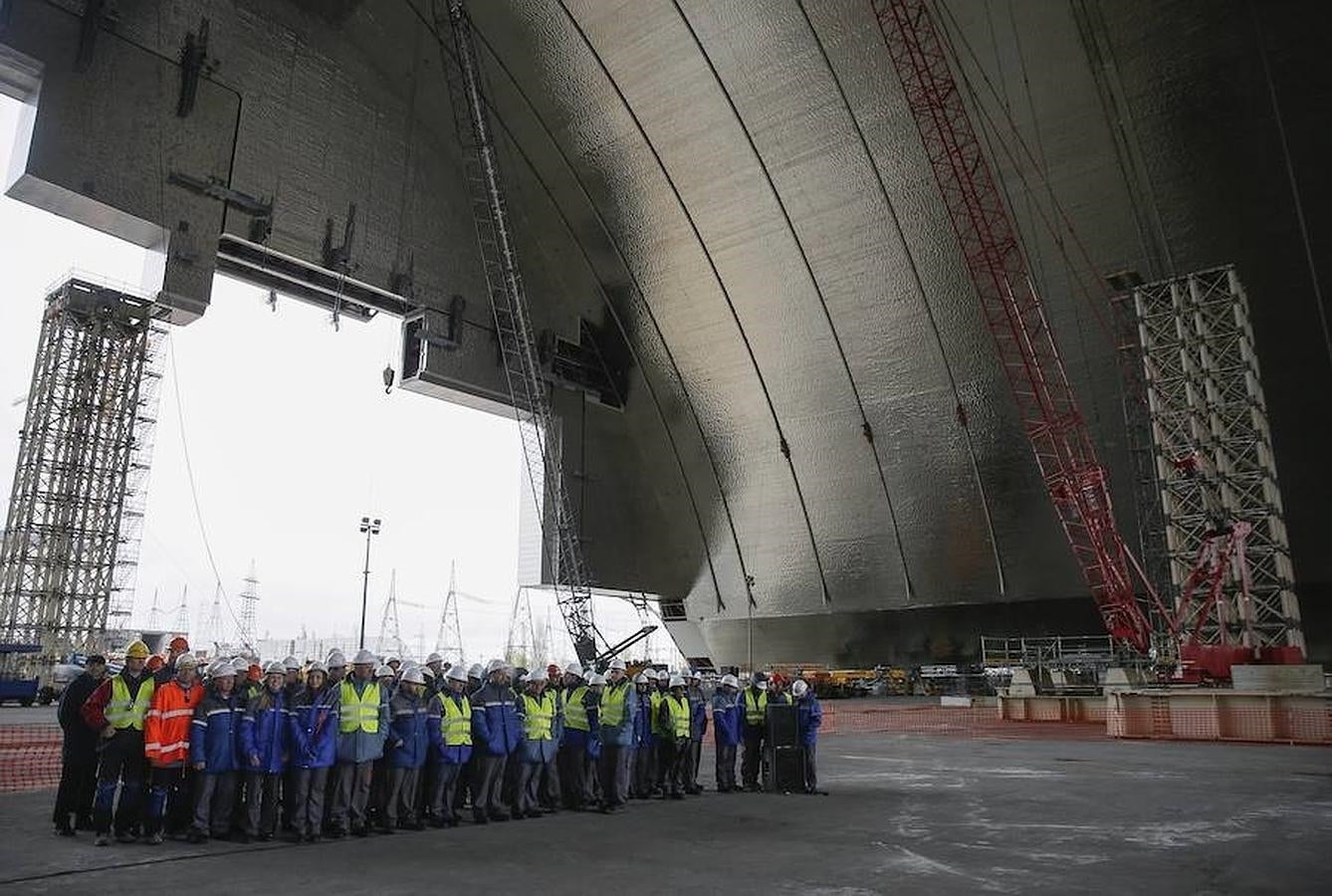 Los trabajadores de la planta nuclear de Chernóbil posan durante una ceremonia con motivo de la construcción de las nuevas instalaciones sobre los restos del reactor número 4, en la planta nuclear de Chernóbil. 