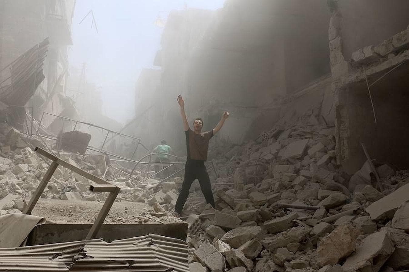 Un hombre pide ayuda tras el bombardeo a la zona rebelde de al-Kalasa en la ciudad siria de Alepo norte