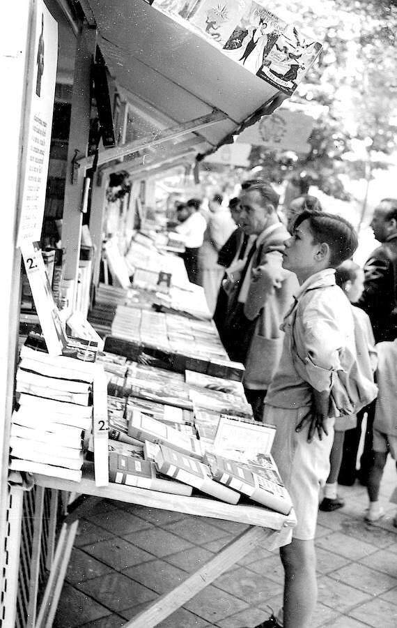 Varios asistentes observan casetas en la feria de 1953