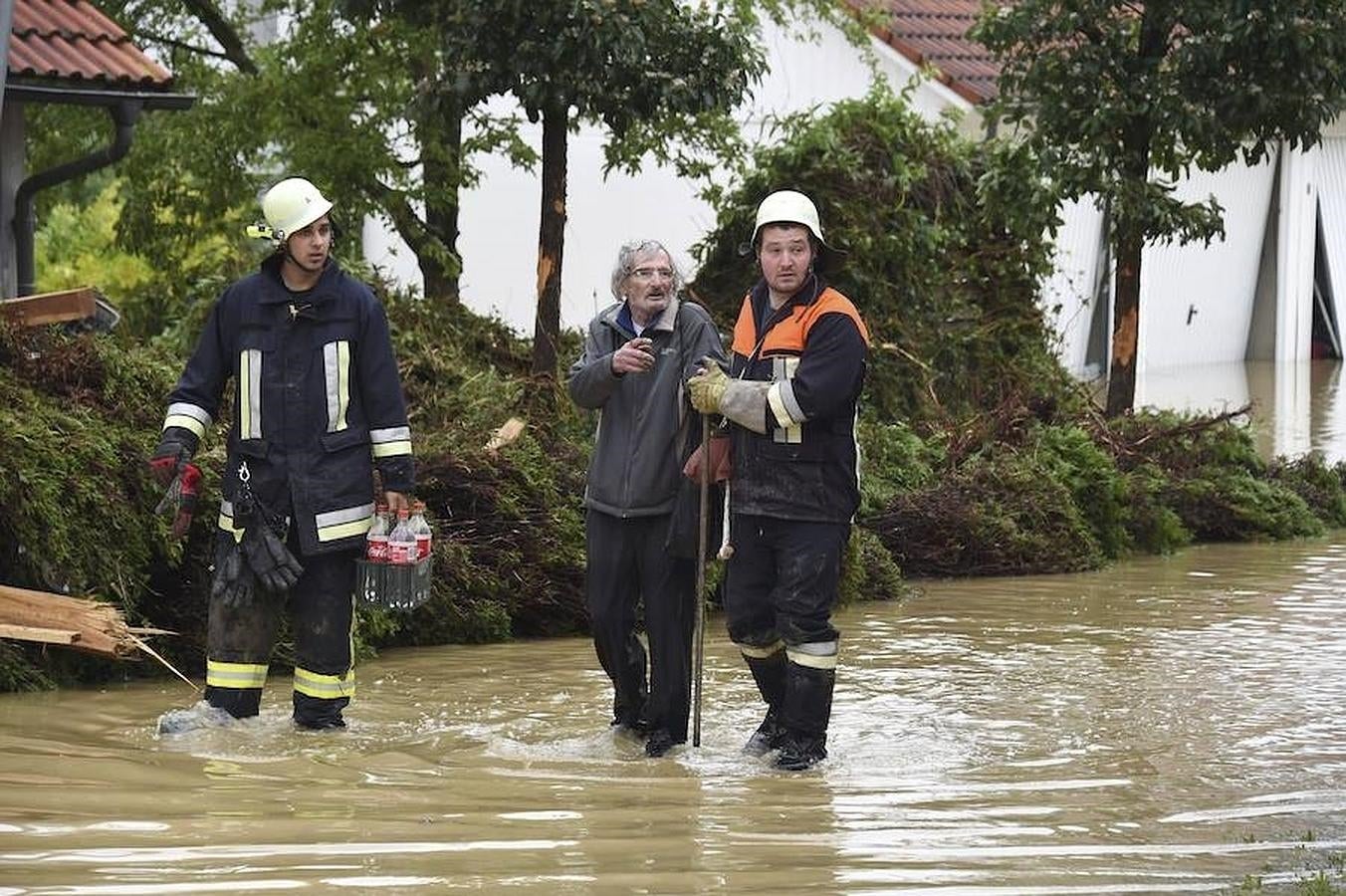 Bomberos ofrecen su ayuda a un vecino de Simbach (Alemania) tras las inundaciones causadas por las fuertes lluvias. 