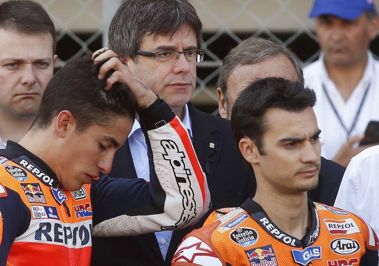 Los pilotos Dani Pedrosa (d) y su compañero de equipo Marc Márquez (i), junto al presidente de la Generalitat de Catalunya, Carles Puigdemont (c), durante el homenaje. 