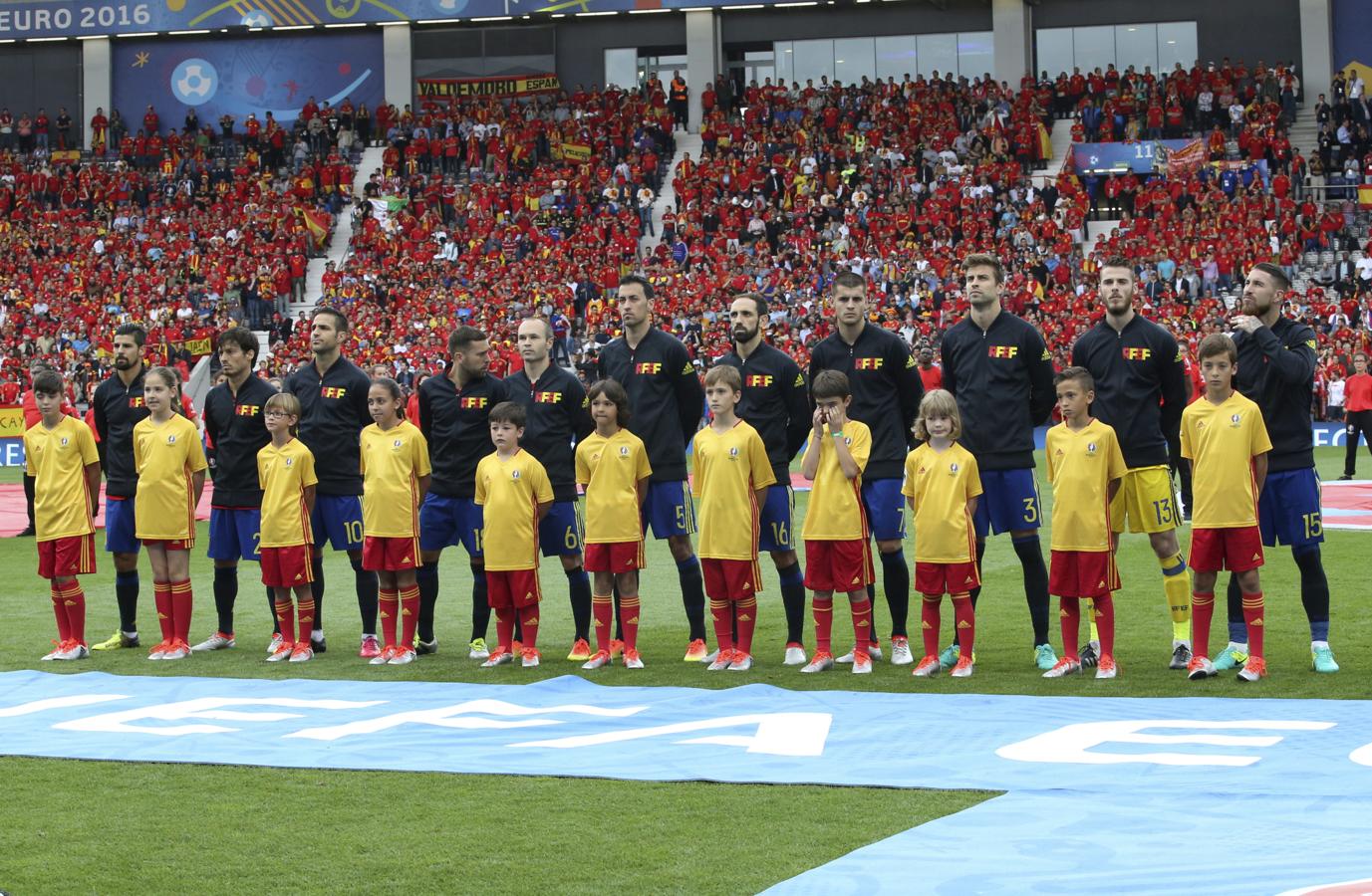 De izquierda a derecha: Sergio, Nerea, Pau, Marta, Eder, Yago, Íñigo, Alejandro, Ariadna, Jose y Javier escuchan junto a nuestros internacionales el himno español. 