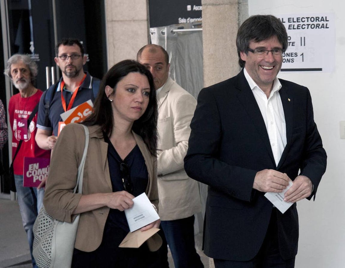 El presidente de la Generalitat, Carles Puigdemont, acompañado de su esposa, Marcela Topor depositado, antes de votar para las elecciones generales en un colegio electoral del centro de Girona. 