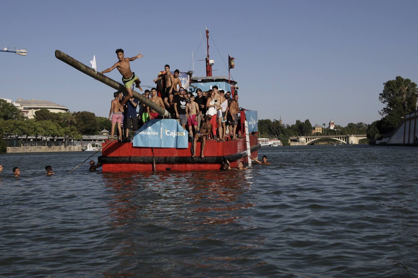 El poste se coloca horizontalmente sobre la proa de una barcaza en el río Guadalquivir