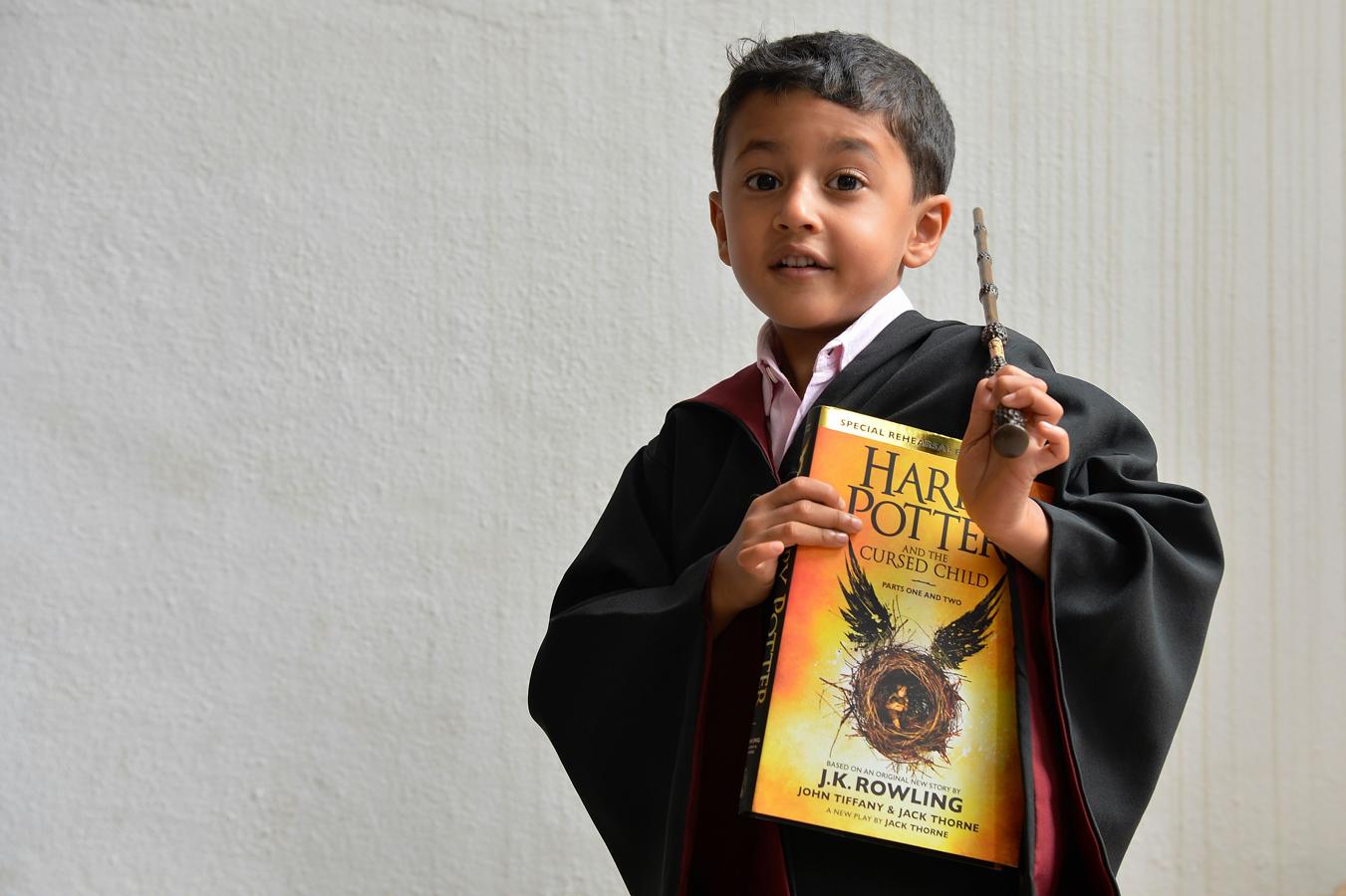 Niño sosteniendo «Harry Potter y el niño maldito» en Bangalore. 