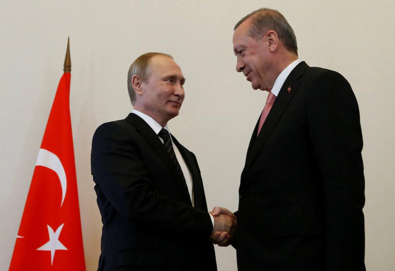 Vladimir Putin y Tayyip Erdogan se entrechan la mano. 