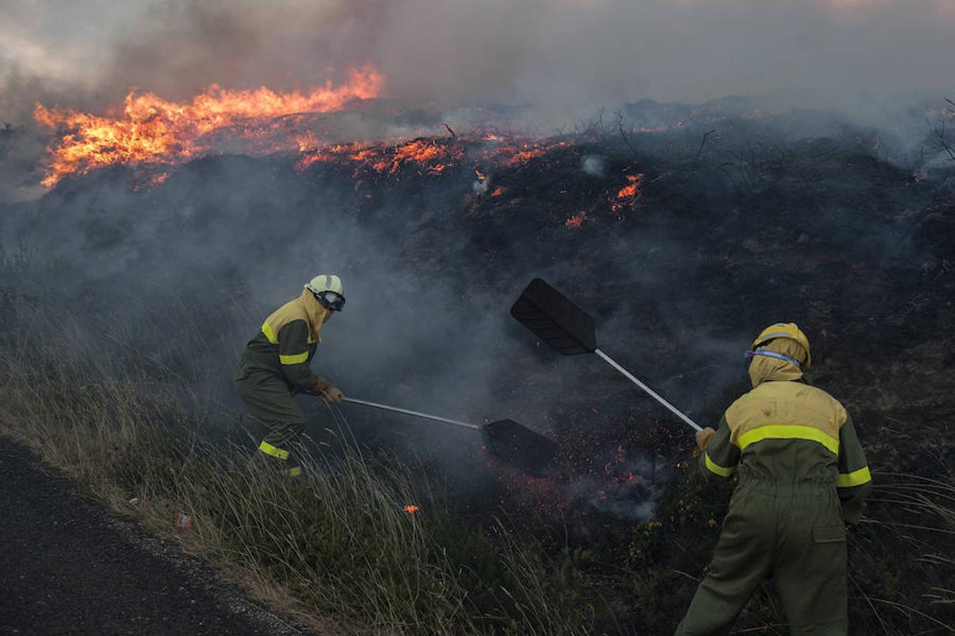 Dos brigadistas durante las labores de extinción del incendio forestal declarado en Avión (Ourense), en la parroquia de Nieva. 