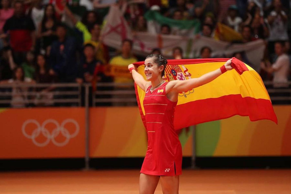 La campeona mundial de badmintón sostiene la bandera española tras ganar los Juegos. 