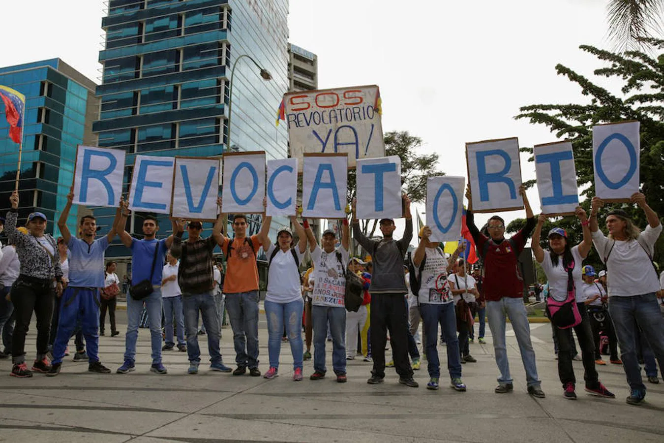 Partidarios de la oposición sostienen pancartas en las que reclaman el revocatorio
