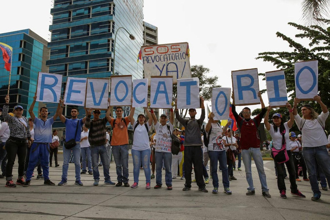 Partidarios de la oposición sostienen pancartas en las que reclaman el revocatorio. 