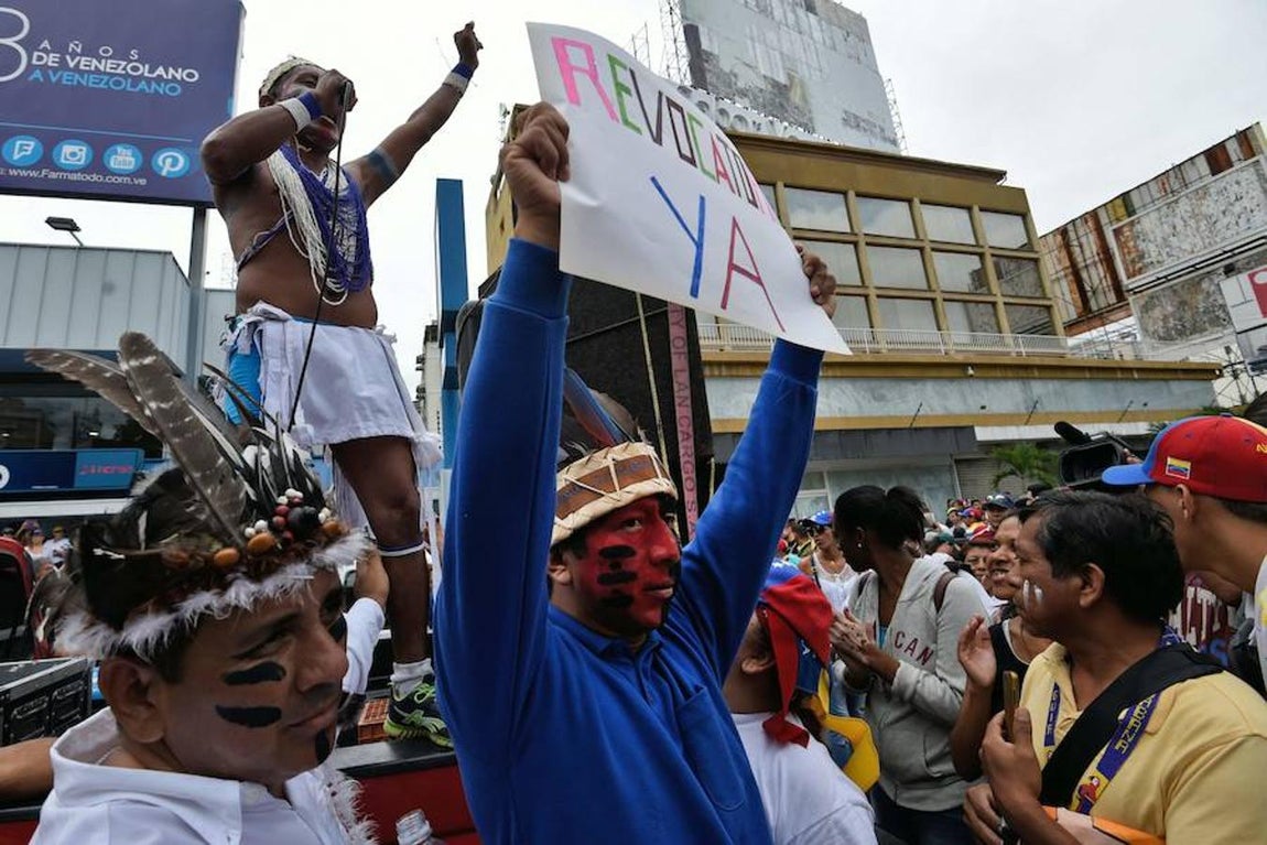 Venezolanos sostienen un cartel con el lema: «Revocatorio ya». 