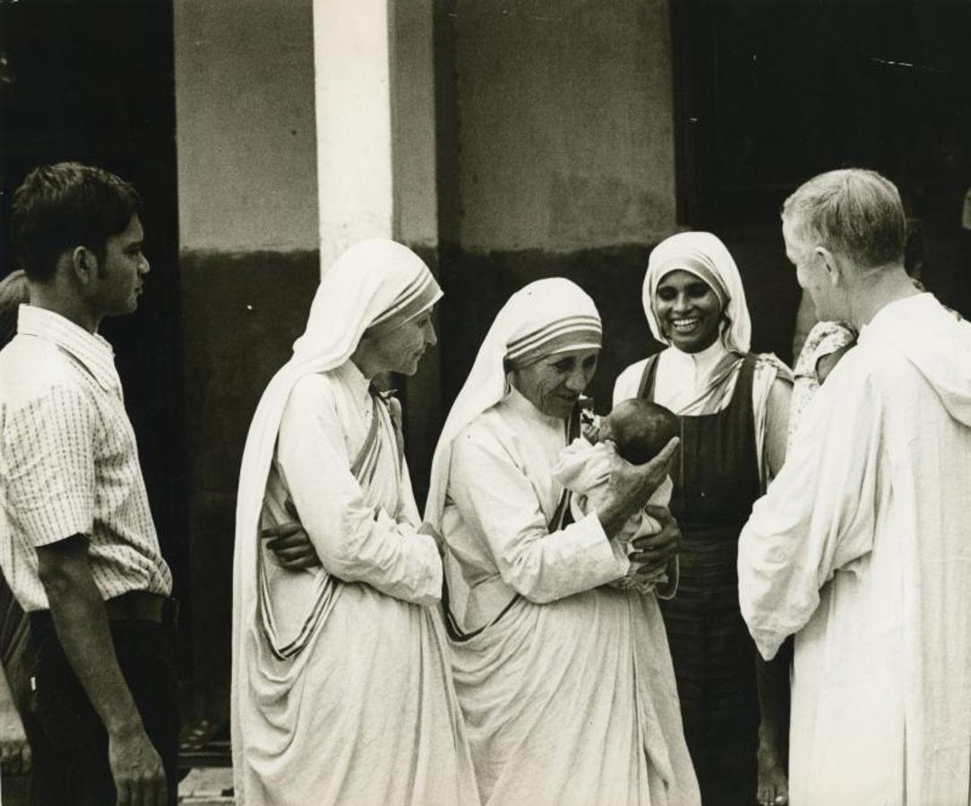 La Madre Teresa de Calcuta con un niño en brazos en su orfanato de la capital india, junto al padre Roger Schultz, fundador de la comuniad ecuménica de Taize, al que invitó para que conociera su obra en noviembre de 1976 en Calcuta.. 