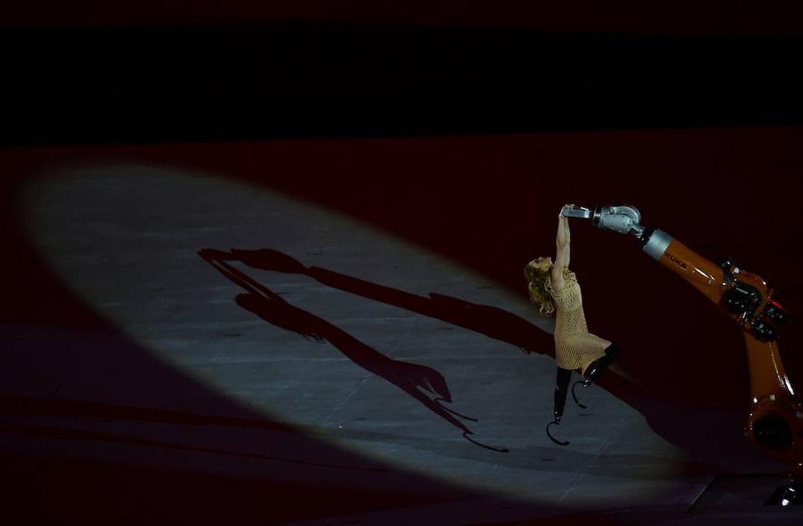 Bailando con una máquina. En referencia a las prótesis y cómo estas permiten la participación de muchos atletas, en el acto de apertura se ha escenificado el baile entre una mujer con prótesis en las piernas y una máquina