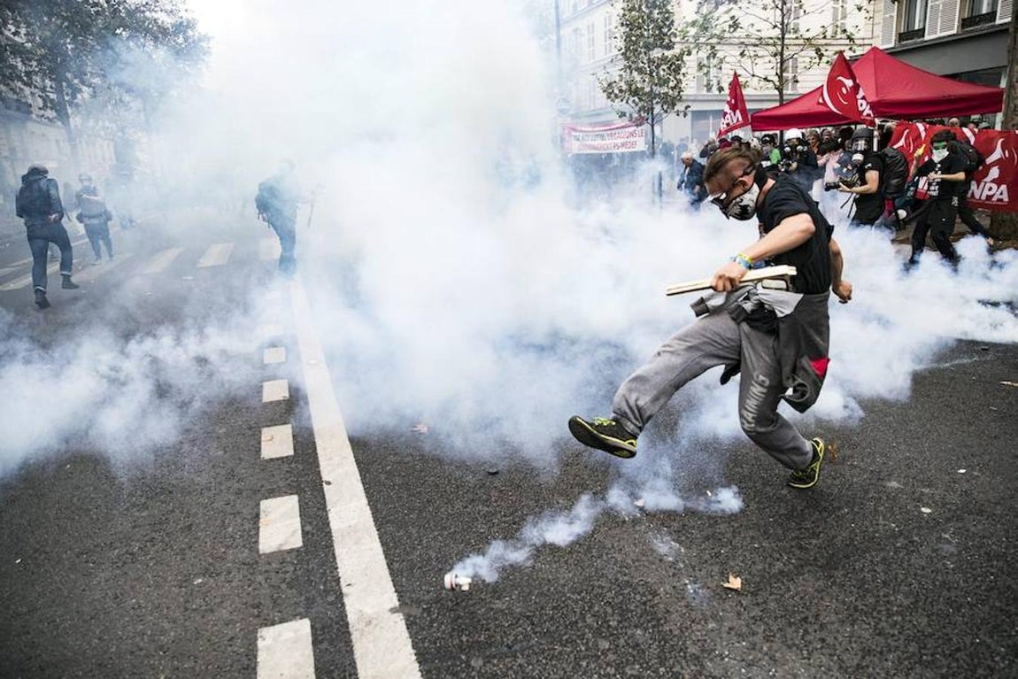 Un manifestante devuelve un bote de gas lacrimógeno lanzado por las fuerzas de seguridad. 