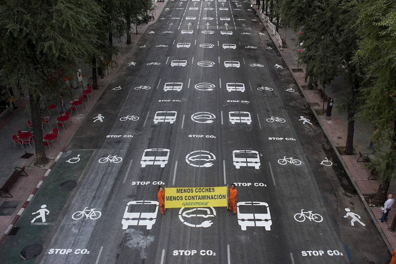 Una veintena de activistas de la organización ecologista han pintado más 200 señales de tráfico en el suelo de la céntrica calle de Bravo Murillo, en Madrid, para pedir menos coches y menos contaminación en los núcleos urbanos