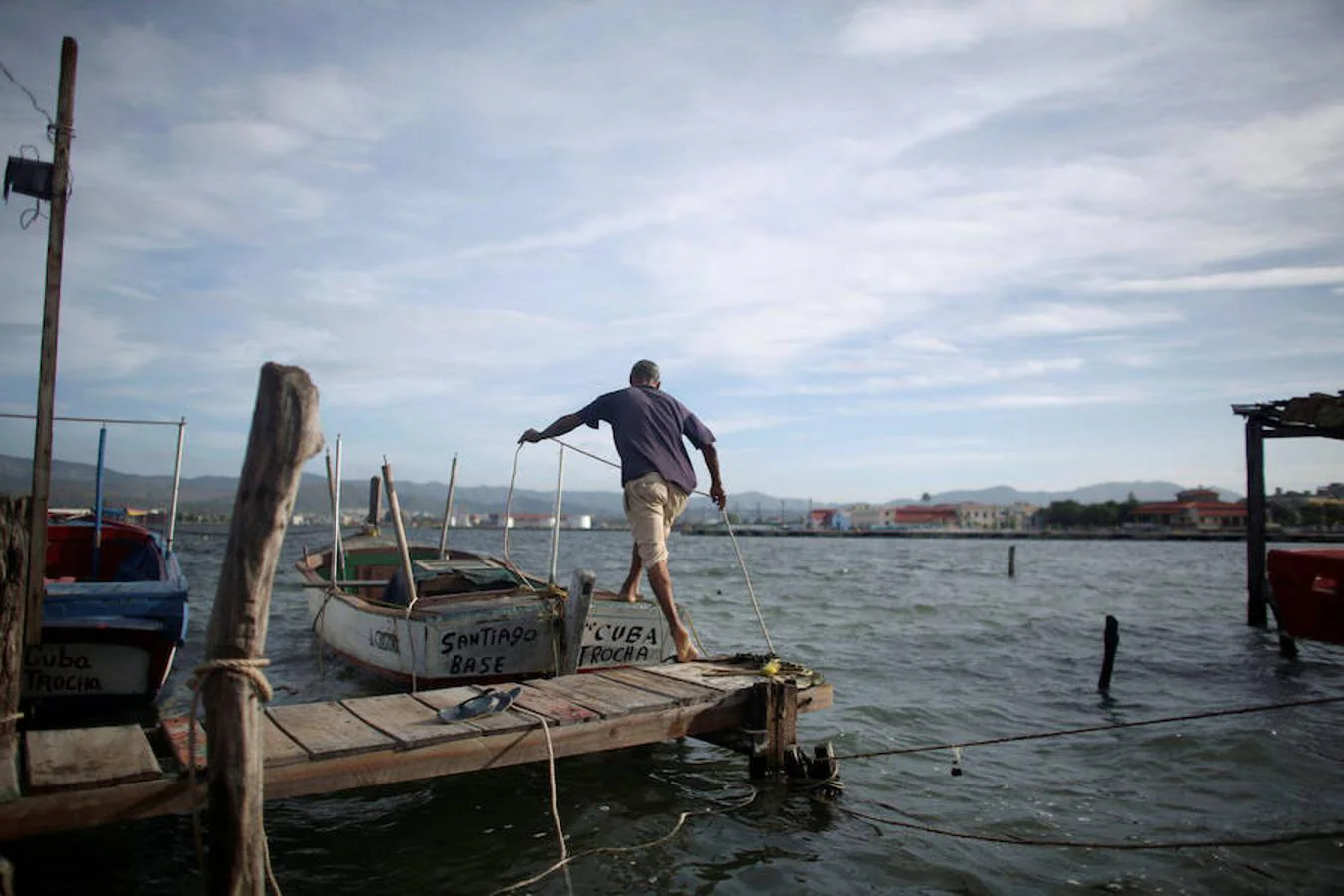 Un pescador salta a su barco en Santiago de Cuba, antes de que el Huracán Matthew alcance el país
