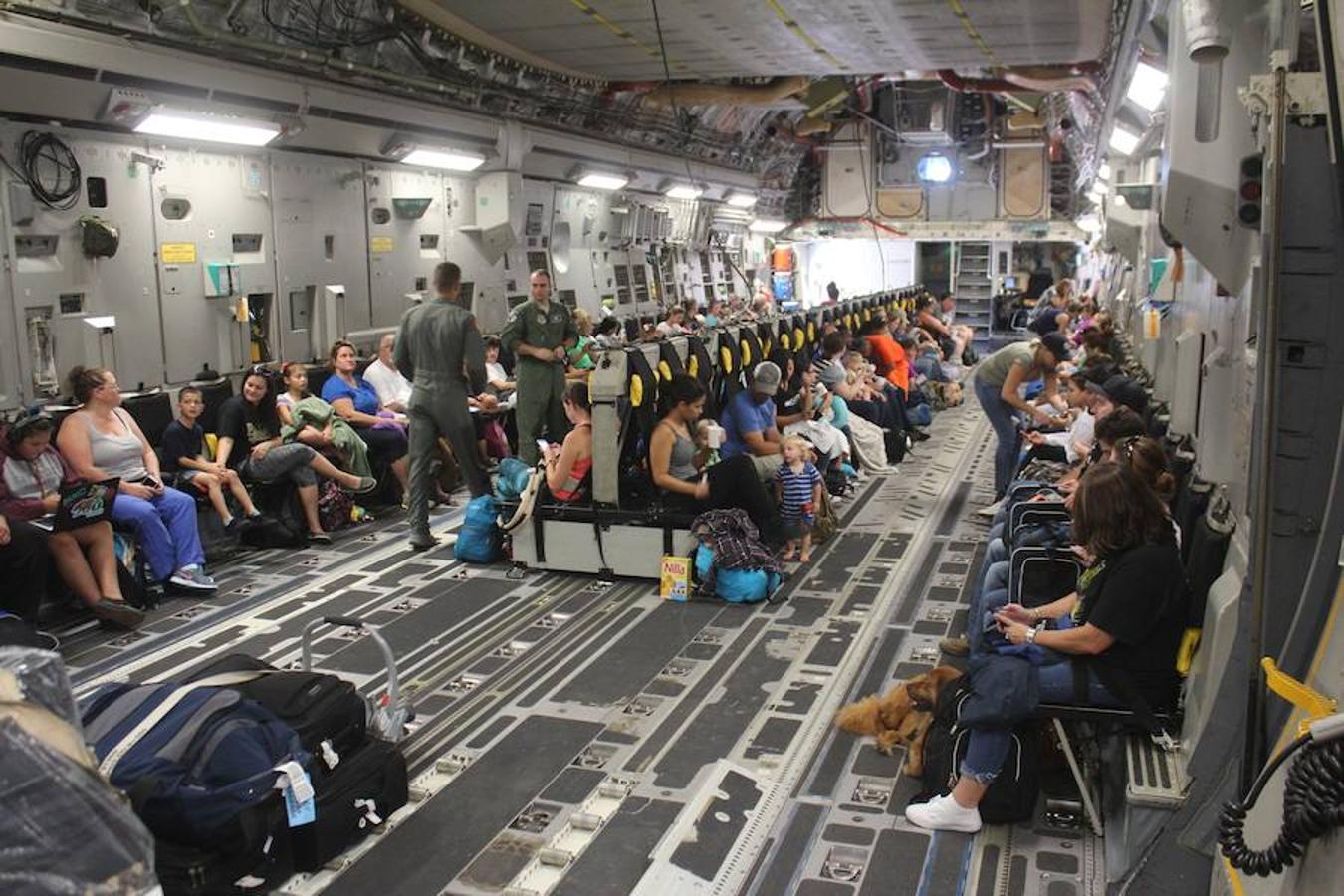 Varias familias permanecen sentadas en un Boeing C-17A Globemaster III durante la evacuación de la base navar de Guantánamo, en Cuba