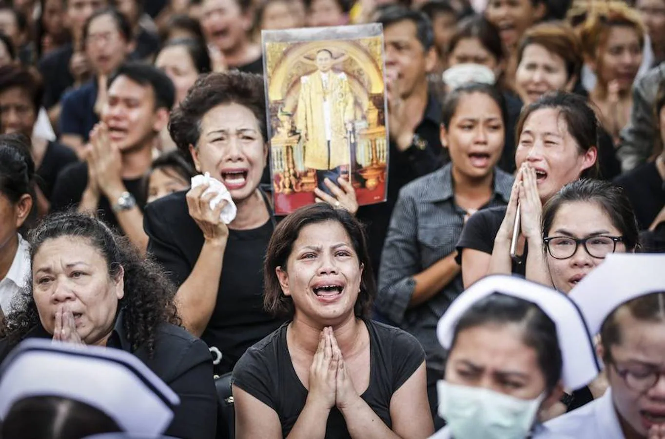Mujeres tailandesas lloran durante la procesión del féretro con los restos mortales del retrato del Rey Bhumibol de Tailandia desde el hospital de Bangkok