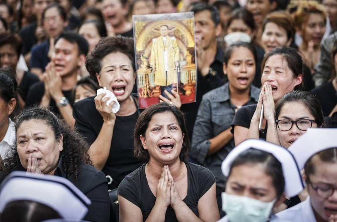 Mujeres tailandesas lloran durante la procesión del féretro con los restos mortales del retrato del Rey Bhumibol de Tailandia desde el hospital de Bangkok. Efe