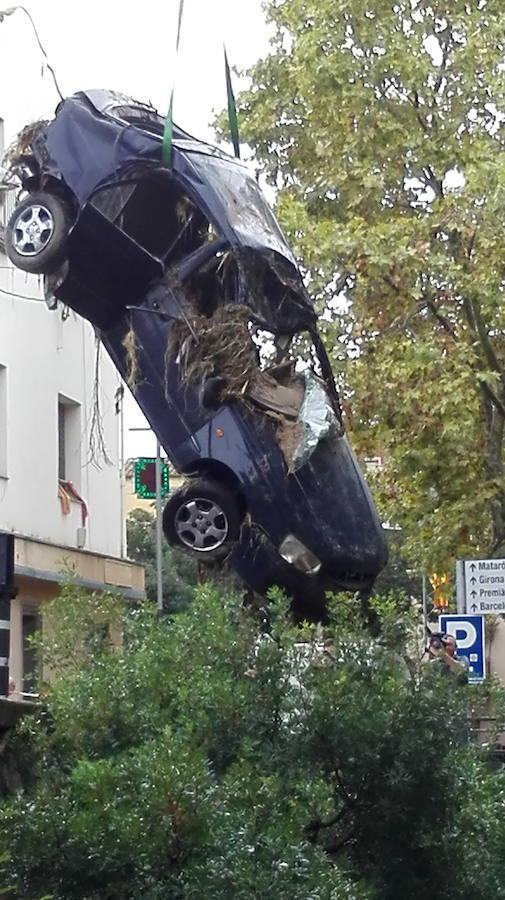 Una grúa se lleva el vehículo en el que murió un hombre al ser arrastrado su coche por el agua en una riera de Vilassar de Mar. 