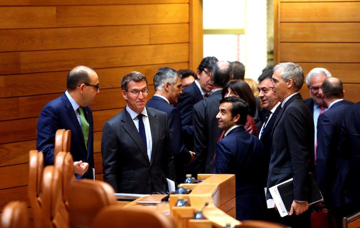 Diputados del PPdeG y miembros del equipo de Feijóo en la Xunta le arropan en el hemiciclo. 