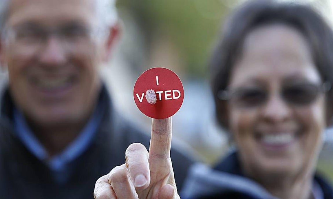 Una pareja de estadounidenses muestra la pegatina de «Yo voté». AFP