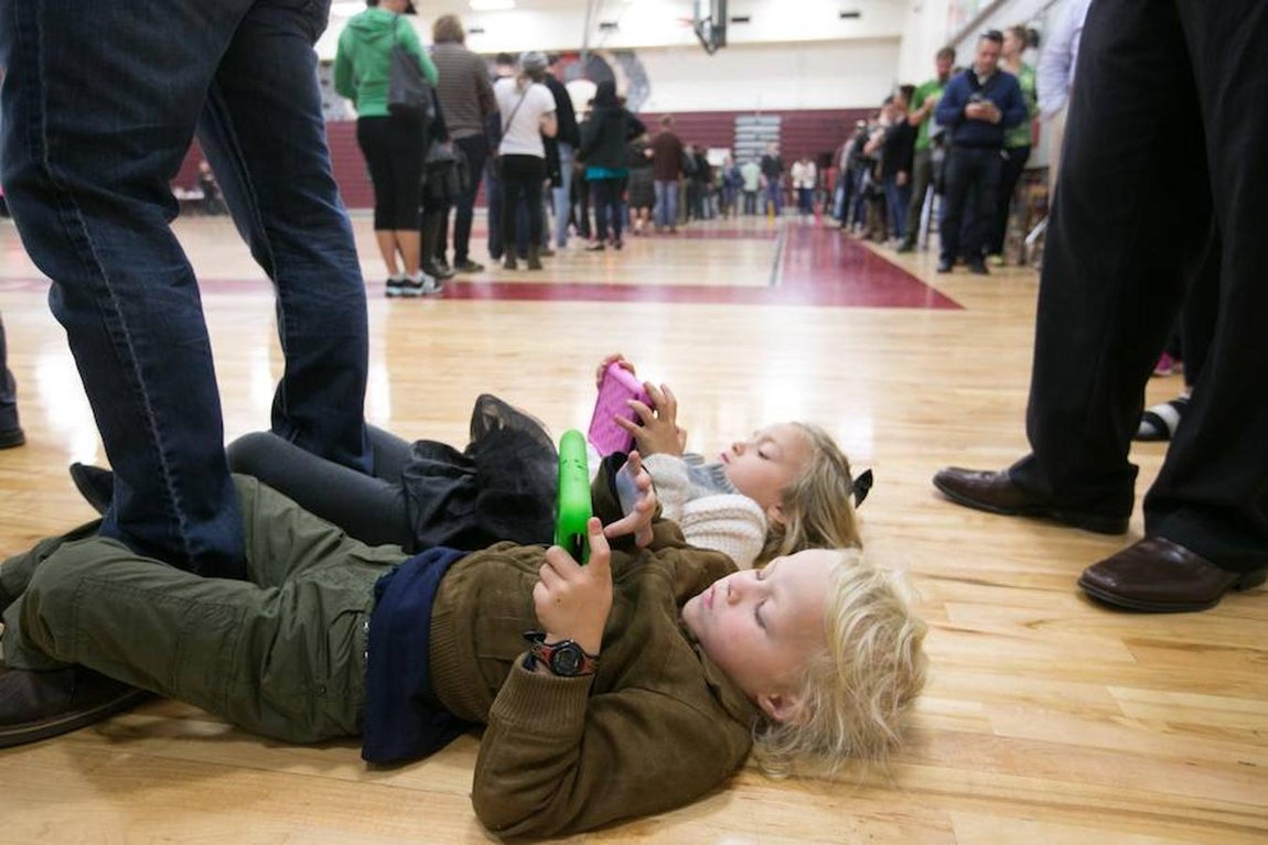Dos niños esperan a que sus padres voten en las elecciones de Estados Unidos 2016. AFP