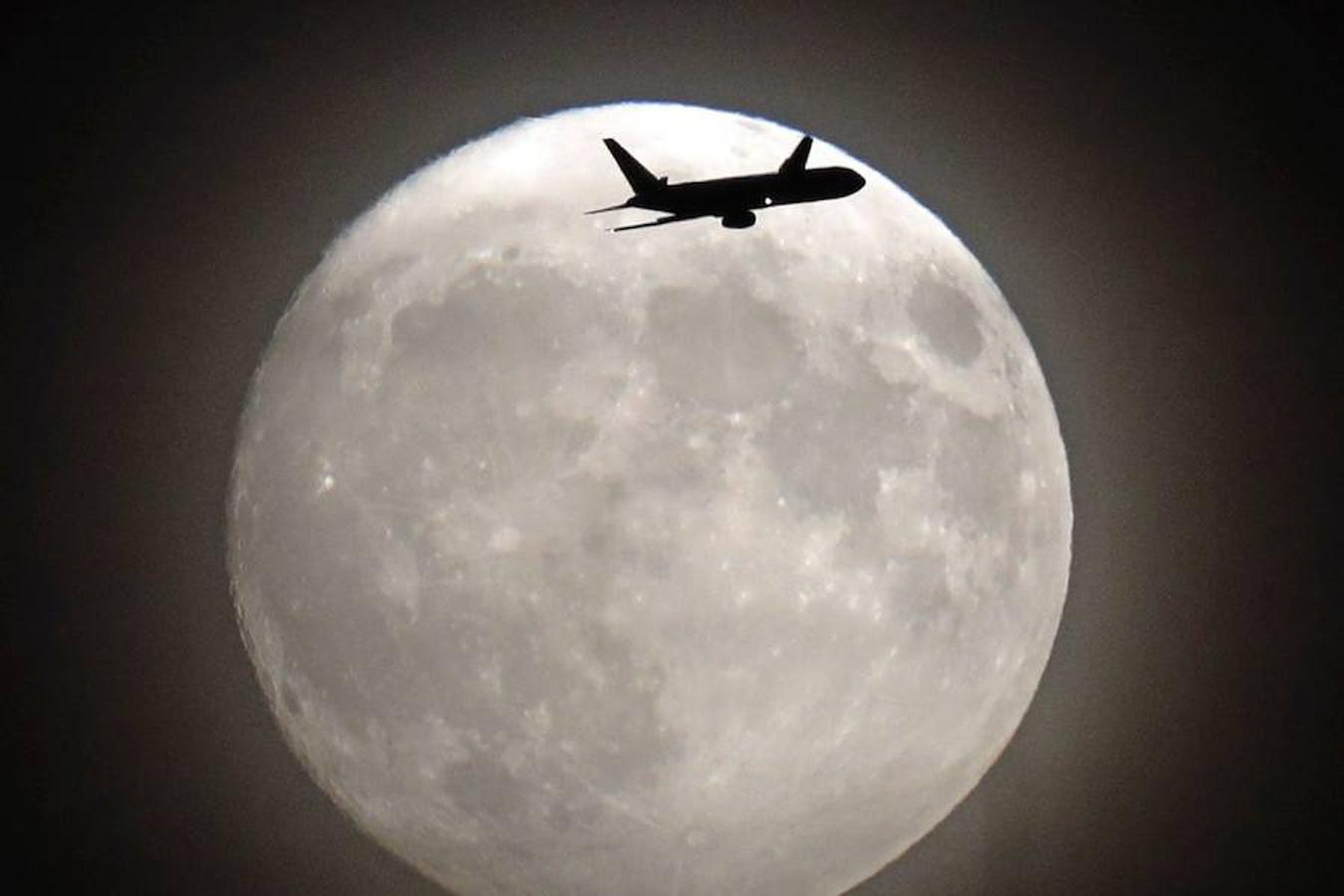 Un avión vuela al lado de la superluna en Londres