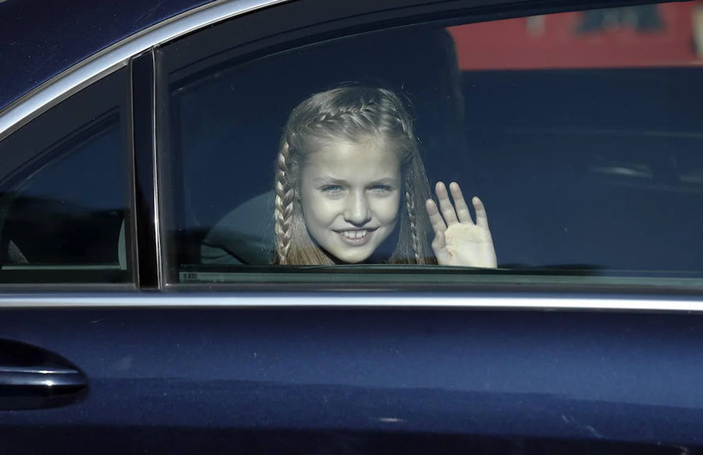 La Princesa Leonor, saluda desde el coche, a su llegada al acto. 