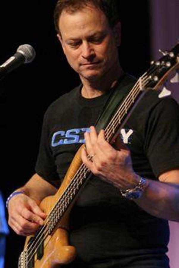 Gary Sinise toca la guitarra. 