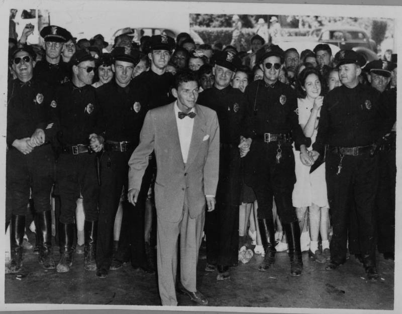 Sinatra fue de los primeros en sufrir el «fenómeno fan». En esta imagen de 1943 la Policía impide a los curiosos que se acerquen a la estrella