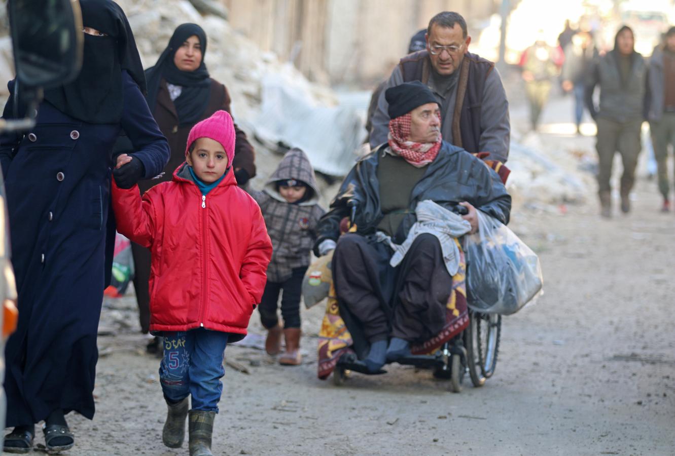 Un grupo de personas abandonan los barrios del este de Alepo para ser evacuados. 