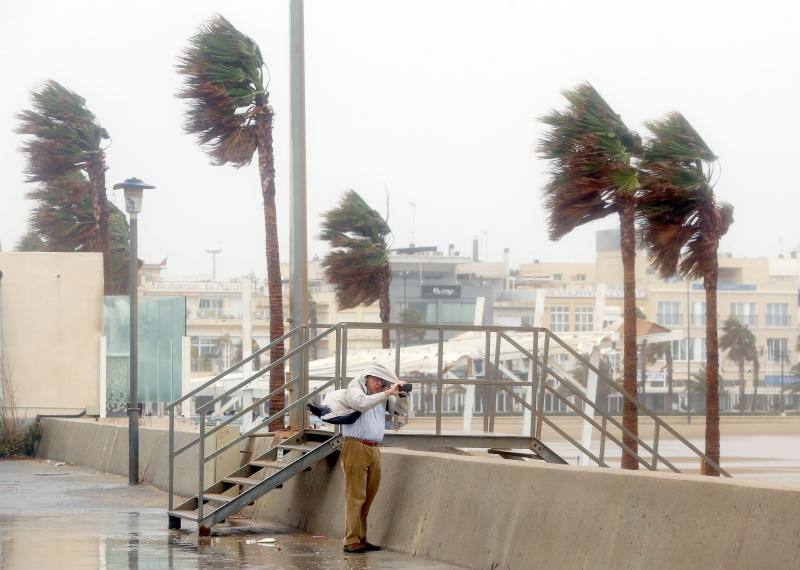 La gota fría en Valencia afecta a un hombre al lado del paseo marítimo. 