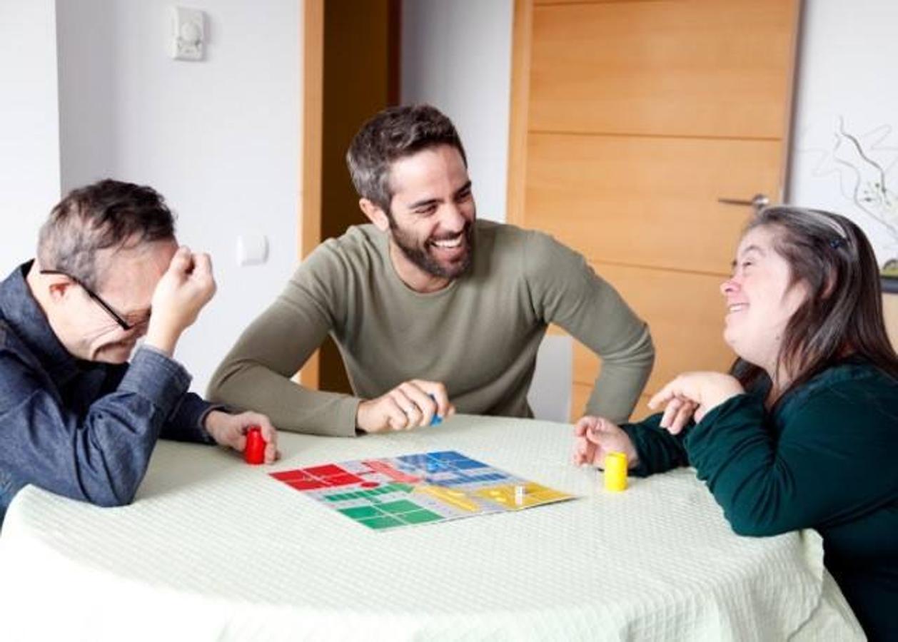 Roberto Leal jugando al parchís con dos jóvenes del Grupo AMAs