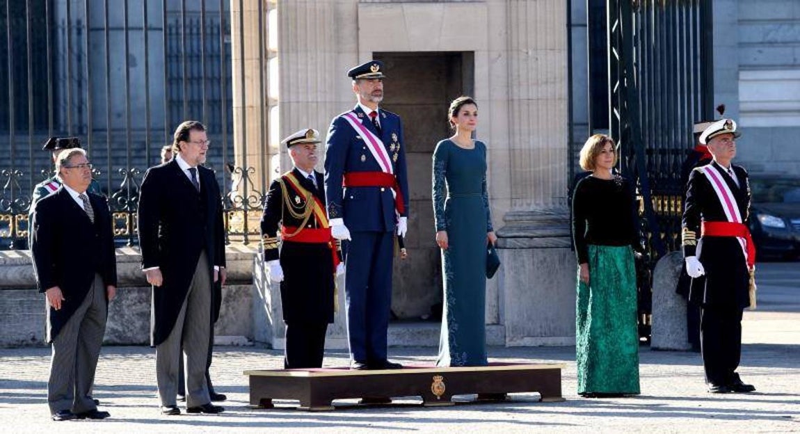 El rey Felipe VI, acompañado por la reina Letizia, junto a la ministra de Defensa, María Dolores de Cospedal (2d), el presidente del Gobierno, Mariano Rajoy (2i), y el ministro del Interior, Juan Ignacio Zoido (i), escuchan el himno nacional en la plaza exterior del Palacio Real, momentos antes de la celebración hoy de la Pascua Militar.. 