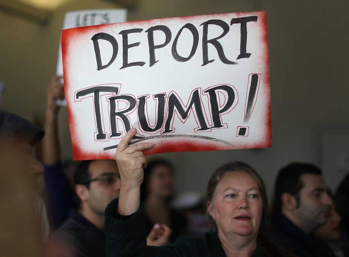 «Deportad a Trump», pide el cartel de esta manifestante del aeropuerto de Miami. 