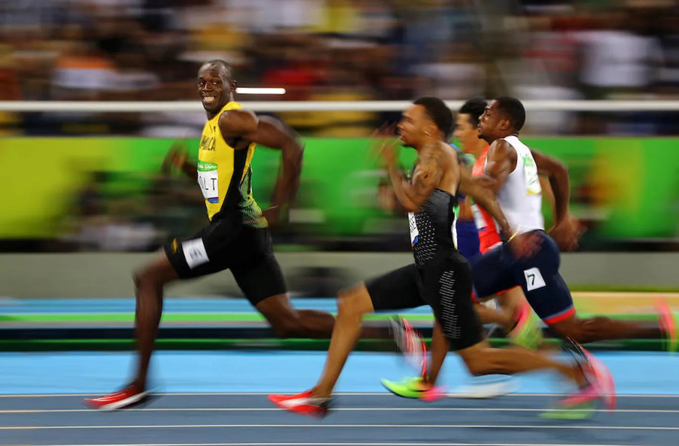 Usain Bolt sonríe mientras mira hacia atrás en la semifinal de los 100 metros lisos en los Juegos Olímpicos. 