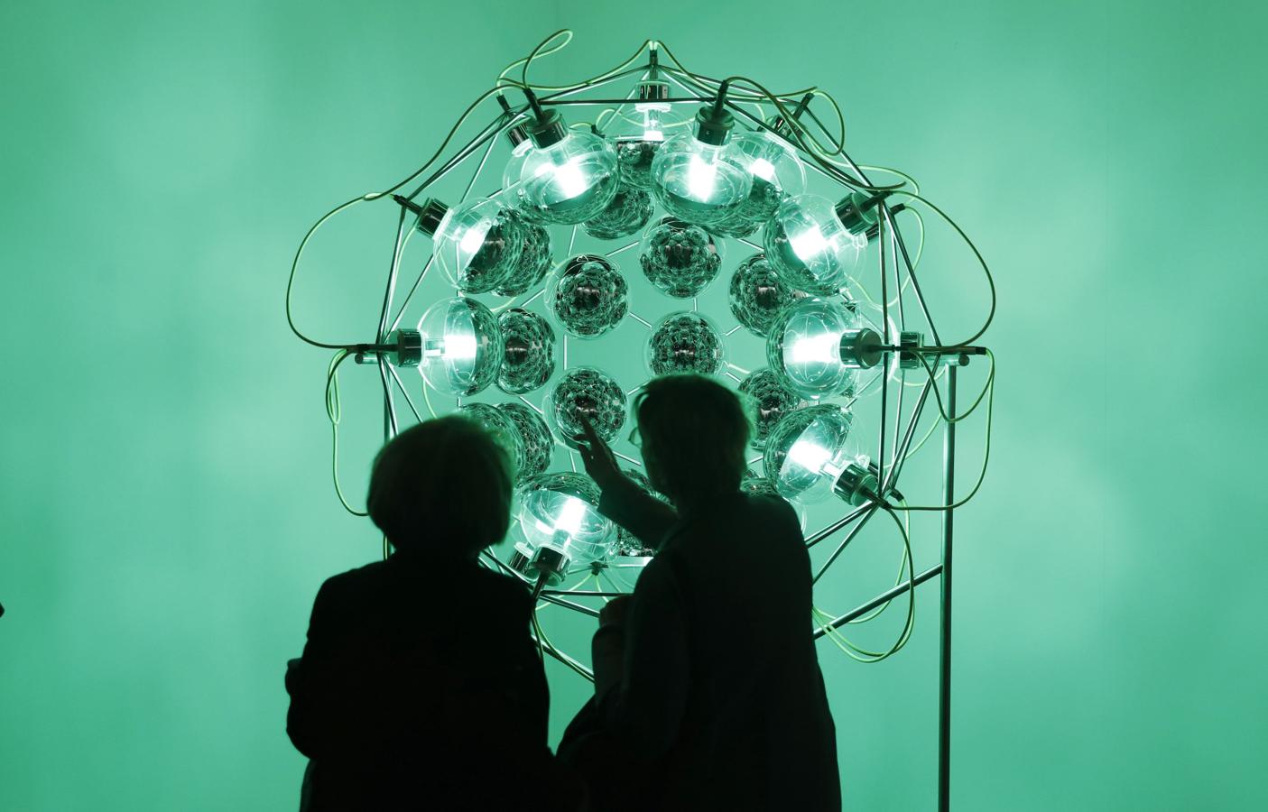 Varias personas observan la obra «Global cooling lamp» (2006), de Olafur Eliasson. 