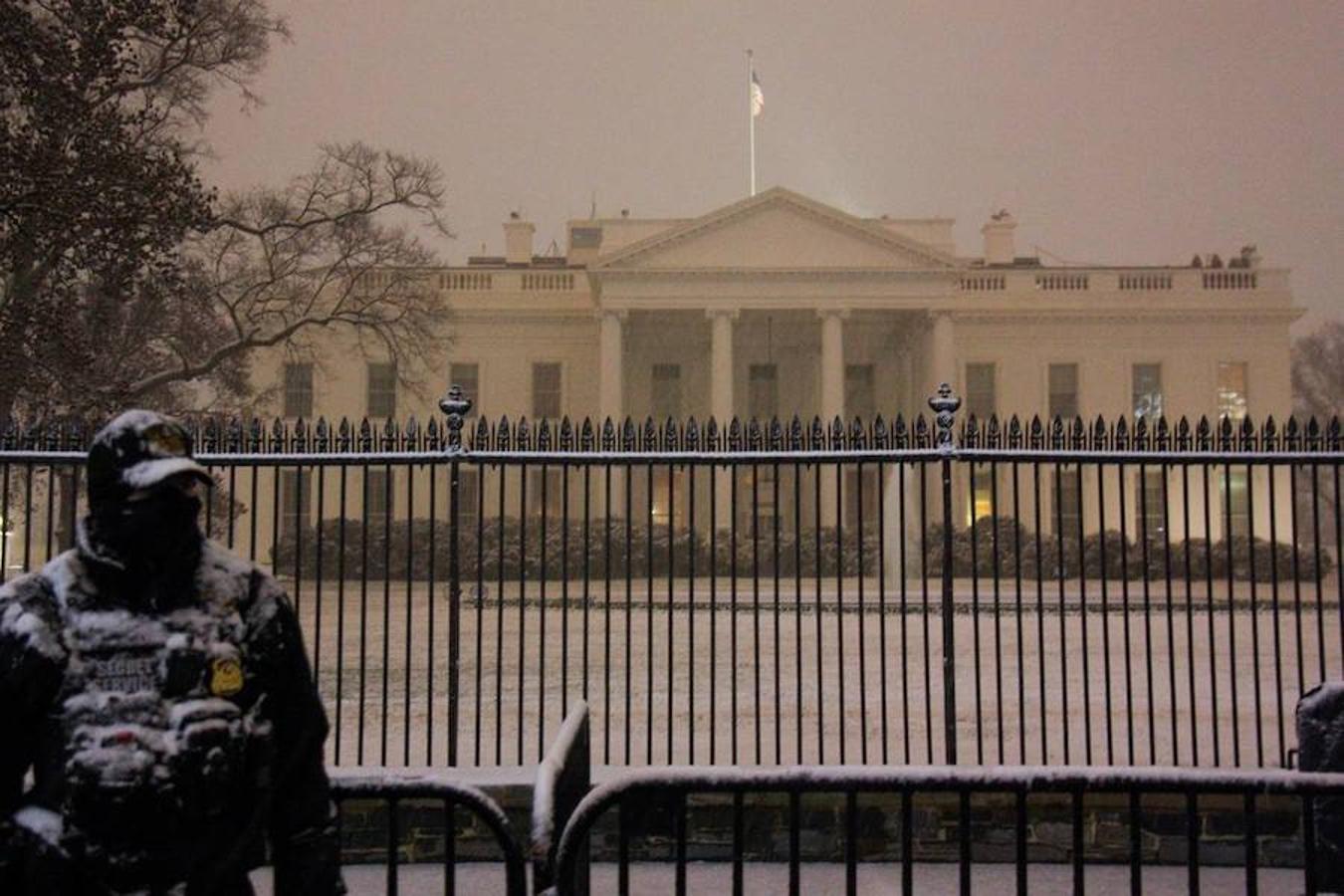 Un agente del servicio secreto custodia la entrada a la Casa Blanca bajo la nevada. 