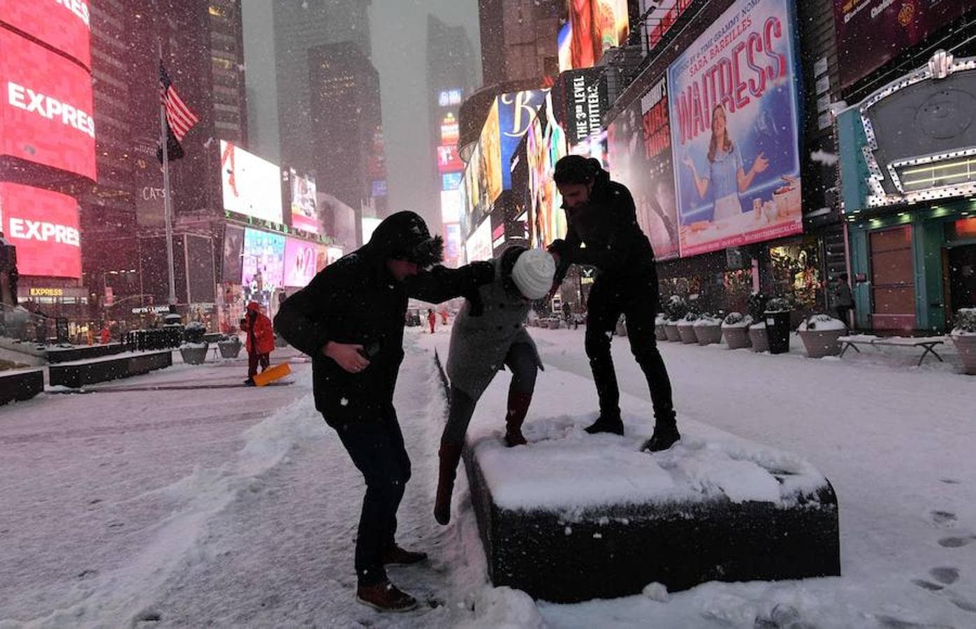 Un grupo de jóvenes juega con la nieve en Times Square